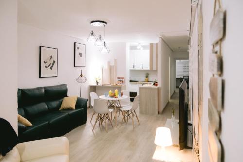 een woonkamer met een zwarte bank en een tafel bij Piso compartido Delyrent, SFJ in Jaén