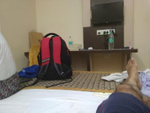 a person laying on a bed with a backpack at Triumph inn Bhubaneswar in Bhubaneshwar