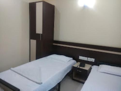 a small room with two beds and a telephone at Triumph inn Bhubaneswar in Bhubaneshwar
