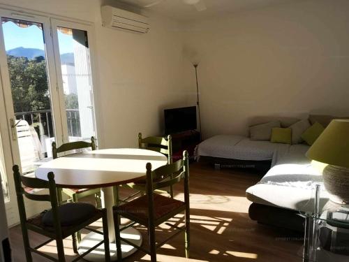 uma sala de estar com uma mesa e um sofá em 4PA72 - Magnifique appartement pour 4 dans résidence avec piscine et parking em Collioure