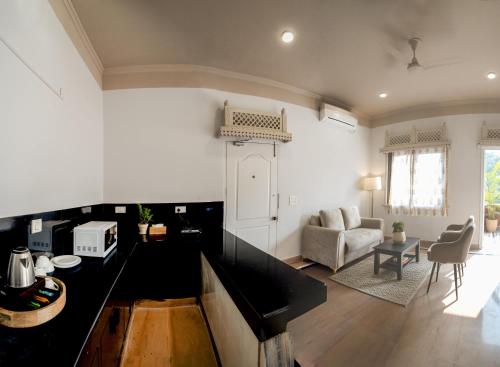 een keuken met een zwart aanrecht en een woonkamer bij Firebrick Boutique Residences - GARNET HOUSE in Gurgaon