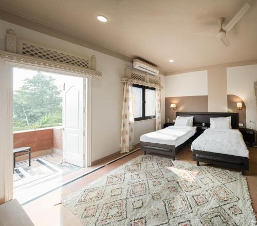 1 Schlafzimmer mit 2 Betten und einem großen Fenster in der Unterkunft Firebrick Boutique Residences - GARNET HOUSE in Gurgaon