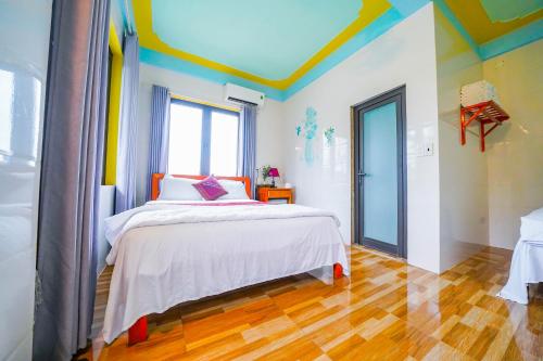 a bedroom with a bed with a colorful ceiling at Phong Nha Escape Bungalow in Phong Nha