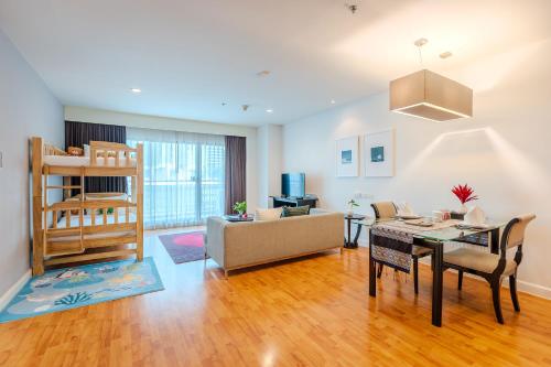 a living room with a couch and a table at Somerset Park Suanplu Bangkok in Bangkok