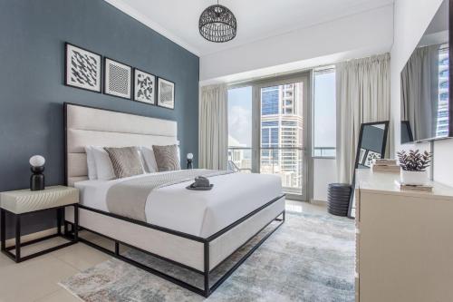 a bedroom with a large white bed and blue walls at Frank Porter - Ocean Heights in Dubai