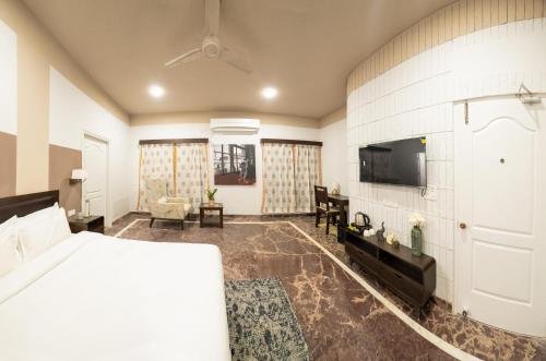 a hotel room with a bed and a tv at Firebrick Boutique Residences - GARNET HOUSE in Gurgaon