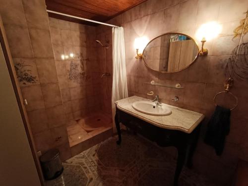 y baño con lavabo y ducha con espejo. en Appartement cozy 100m2 dans chalet savoyard, en Magland