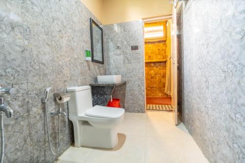 La salle de bains est pourvue d'une douche et de toilettes. dans l'établissement HABITAS RHINO BY NATURE HUNT, à Kāziranga