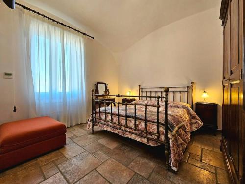 1 dormitorio con 1 cama, 1 silla y 1 ventana en Casale di lusso panoramico en Lettere