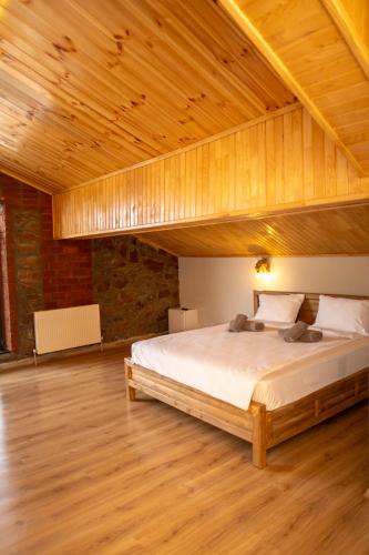 a bedroom with a large bed with a wooden ceiling at Eylül Butik Hotel in Tunceli