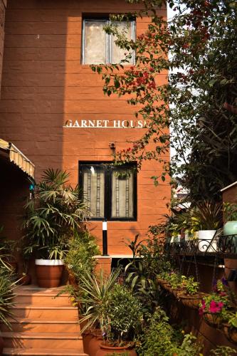 a building with a sign that reads garden house at Firebrick Boutique Residences - GARNET HOUSE in Gurgaon
