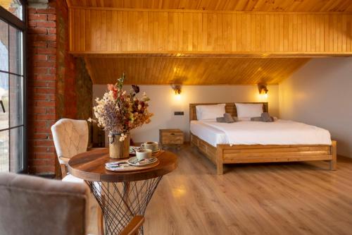 Eylül Butik Hotel في تونجيلي: غرفة نوم بسرير وطاولة عليها ورد