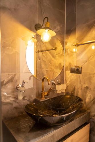 baño con lavabo negro y espejo en Eylül Butik Hotel en Tunceli