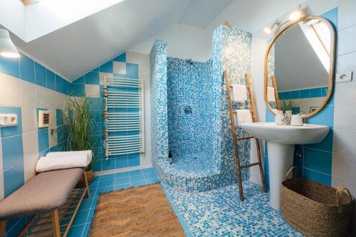 baño azul con ducha y lavamanos en Carpathian Loft with Private Parking, en Odorheiu Secuiesc
