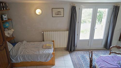 La RochetteにあるGîtes de Saint-Ribert 6 piècesのベッドとガラスの引き戸のある寝室