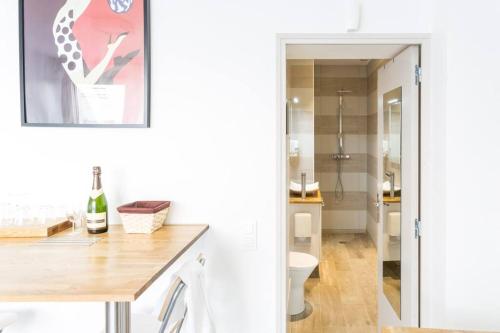 La salle de bains blanche est pourvue de toilettes et d'un lavabo. dans l'établissement Tranquilis - Studio hypercentre terrasse parking, à Reims