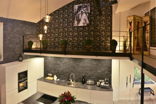 uma cozinha com um lavatório e uma lareira em Le LOFT, MoonLOVE, Jacuzzi et sauna privatifs sur terrasse, 120m2 em Jarville-la-Malgrange