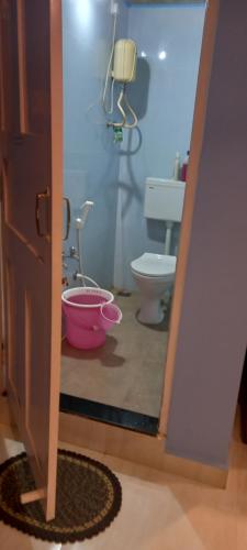 La salle de bains est pourvue de toilettes et d'un seau rose. dans l'établissement Serene Homestay (Mini -For 2 to 3 Guest), à Panaji