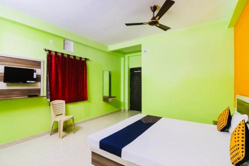 een slaapkamer met een bed en een plafondventilator bij Hotel Sand Castle ! Puri in Puri