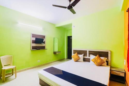een slaapkamer met een bed met groene muren en een plafond bij Hotel Sand Castle ! Puri in Puri