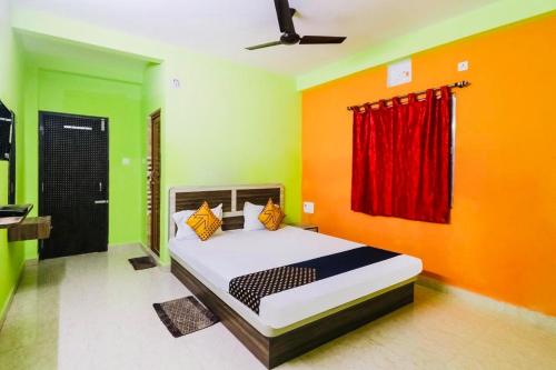 een slaapkamer met een bed met oranje en groene muren bij Hotel Sand Castle ! Puri in Puri