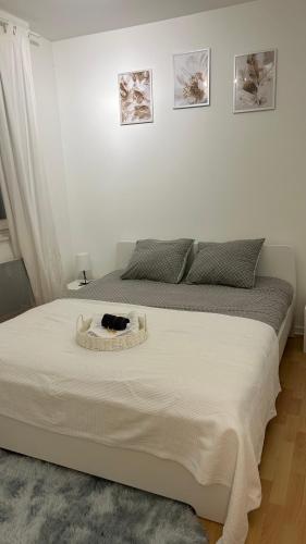 - un chat assis sur un lit dans une chambre dans l'établissement Appartement frontière Luxembourg, à Thionville