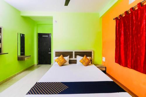 een slaapkamer met een bed met groene en oranje muren bij Hotel Sand Castle ! Puri in Puri