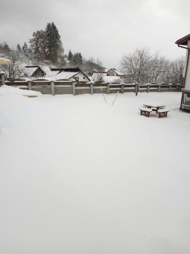 a picnic table sitting on top of a snow covered field at MONADIN Villa Relax & Spa in Săcele