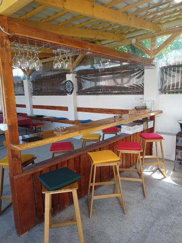 a bar with colorful stools in a room at MONADIN Villa Relax & Spa in Săcele