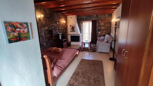 a room with a bed and a living room at ΞΕΝΩΝΑΣ ΘΕΑ in Palaios Agios Athanasios