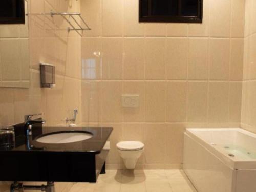 a bathroom with a sink and a toilet and a tub at Sanna Boutique Hotel in Arusha
