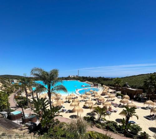 ein Resort mit einem Pool und Sonnenschirmen sowie einem Strand in der Unterkunft Industrial Loft estudio in Estepona
