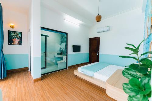 a bedroom with a bed and a potted plant at Blossom Sea Homestay Quy Nhơn in Quy Nhon