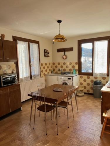 une cuisine avec une table et des chaises dans une pièce dans l'établissement Villa Le Rocher, à Villar-Saint-Pancrace