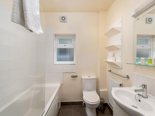 a white bathroom with a toilet and a sink at Pass the Keys Family Friendly 3 Bed Home In Pinner Pets Welcome in Pinner