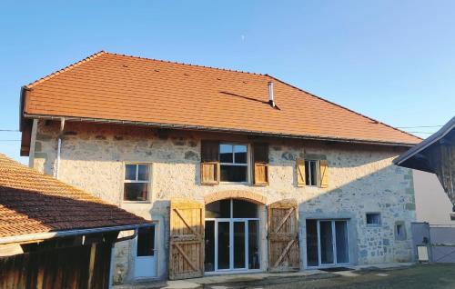 une ancienne maison en pierre avec un toit orange dans l'établissement Au Coin Du Chemin, à Chambéry