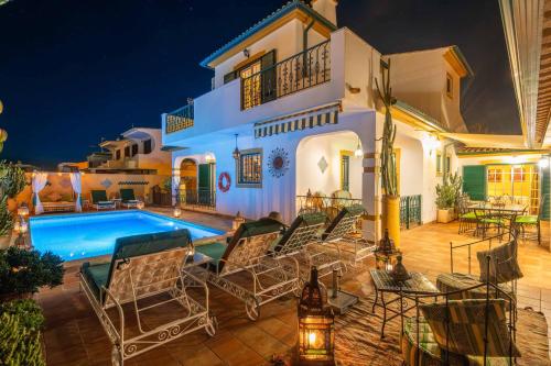 a villa with a swimming pool at night at Riad Serpa Galé - Luxury, private pool, AC, wifi, 5 min from the beach in Guia