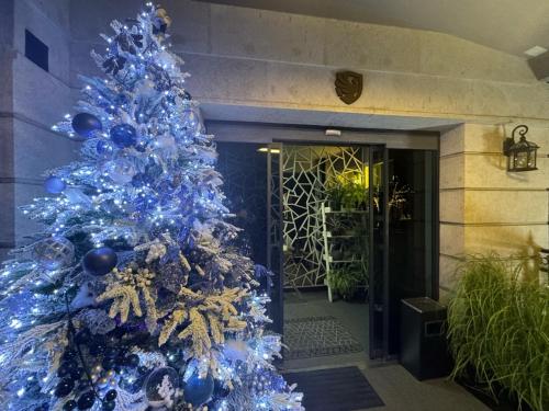 a blue christmas tree in front of a building at The Phoenix Boutique Hotel in Yerevan