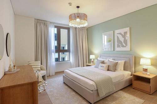 a bedroom with a large bed and a chandelier at HiGuests - Family Dream Escape with Private Beach Access in Dubai
