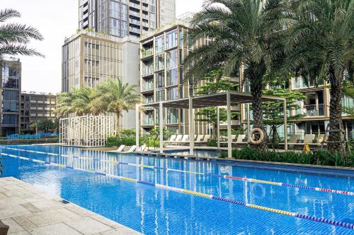 une grande piscine avec des palmiers et des bâtiments dans l'établissement 2 Master 5 Min To D1 Pool & Bbq, à Hô-Chi-Minh-Ville