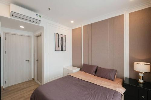 1 dormitorio con cama y pared blanca en Compassone - 2bd Luxury Apartment Free Gym & Pool, en Ấp Phú Thọ