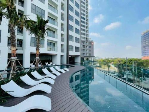 a walkway with white chairs and a building at Compassone - 2bd Luxury Apartment Free Gym & Pool in Ấp Phú Thọ