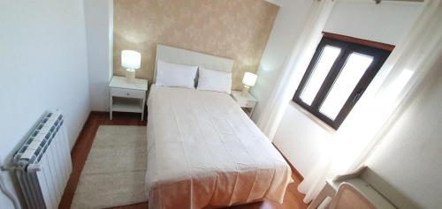 ein Schlafzimmer mit einem großen weißen Bett in einem Zimmer in der Unterkunft Caldas da Rainha's Green & Brown in Caldas da Rainha