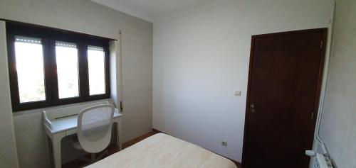 a room with a toilet and a window and a chair at Caldas da Rainha's Green & Brown in Caldas da Rainha