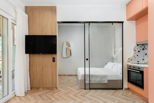 - une chambre avec un lit et une porte en verre dans l'établissement Lagon Suite by Alchemia, à Thessalonique
