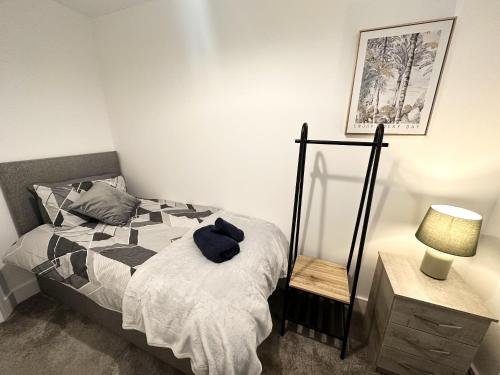 een slaapkamer met een bed, een lamp en een spiegel bij Fairway Villa in Stafford