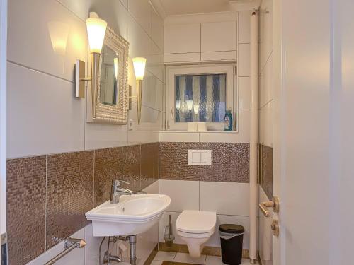 y baño con lavabo, aseo y espejo. en T&K Apartments - Erkrath - 4 Zimmer Apartments, en Erkrath