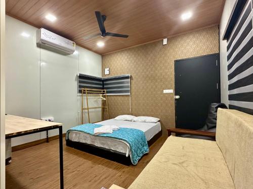a bedroom with a bed and a desk and a table at WHOOSH HOMES in Cochin