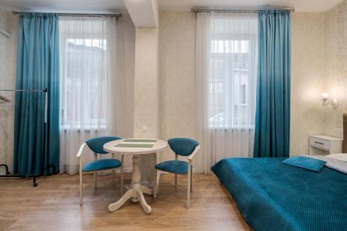 - une chambre avec un lit, une table et des chaises dans l'établissement Luxury flat near Opera, à Lviv