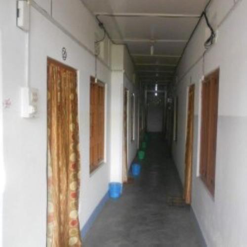 einen leeren Flur eines Gebäudes mit Türen und Fenstern in der Unterkunft Hotel 4-U Assam 
